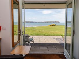 A living room with a view of the sea and a chair at Ty Mor in Newport, Pembrokeshire
