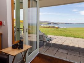A doorway with a view of the sea and lawn at Ty Mor in Newport, Pembrokeshire