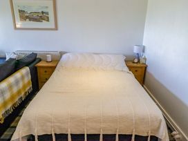 A bedroom with a bed and nightstand at Ty Mor in Newport, Pembrokeshire