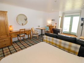 A living room with a sofa, desk and wardrobe at Ty Mor in Newport, Pembrokeshire