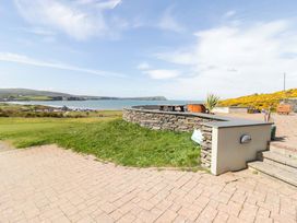 An outdoor area with a stone wall and view of the sea at Ty Mor in Newport, Pembrokeshire