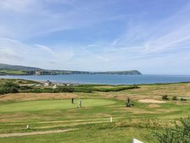 A golf course with golfers near the ocean at Ty Mor in Newport, Pembrokeshire