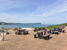 An outdoor seating area with tables and benches overlooking the sea at Ty Mor in Newport, Pembrokeshire
