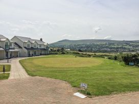 A golf area with houses and a mountain in the background at Ty Mor in Newport, Pembrokeshire