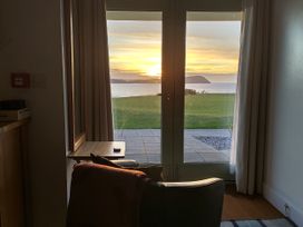 A living room with a view of the sunset over the sea at Ty Mor Newport, Pembrokeshire