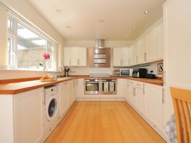 A kitchen with a washing machine and oven at Porthmeor in Wadebridge