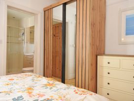 A bedroom with a bed and a wardrobe at Porthmeor in Wadebridge