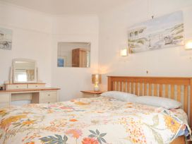 A bedroom with a bed and dresser at Porthmeor Wadebridge