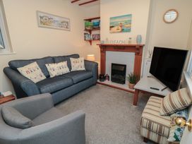 A living room with a sofa, armchair, and television at Seabreeze in Filey