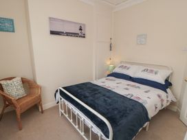 A bedroom with a bed and chair at Seabreeze in Filey