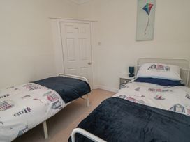 A bedroom with two beds and a bedside table at Seabreeze in Filey