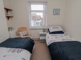 A bedroom with two beds and a chair at Seabreeze in Filey