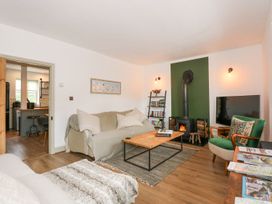 A living room with a sofa, coffee table, and fireplace at Joy's Cottage in Snettisham