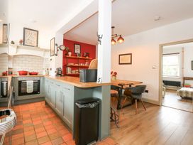 A kitchen with cabinets and a dining table at Joy's Cottage in Snettisham