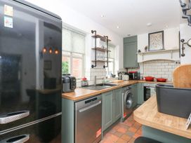 A kitchen with appliances and wooden counters at Joy's Cottage in Snettisham