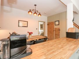 A kitchen with a table and coffee machine at Joy's Cottage in Snettisham