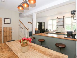 A kitchen with a table and stools at Joy's Cottage Snettisham