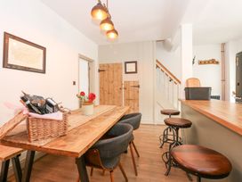 A dining room with a wooden table and chairs at Joy's Cottage in Snettisham