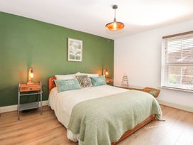 A bedroom with a bed and nightstand at Joy's Cottage in Snettisham