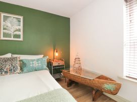 A bedroom with a bed and bedside table at Joy's Cottage in Snettisham