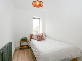 A bedroom with a bed and a window at Joy's Cottage Snettisham