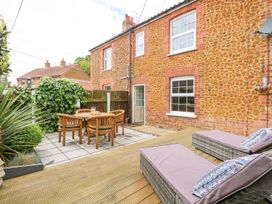 A garden with a table and chairs at Joy's Cottage in Snettisham