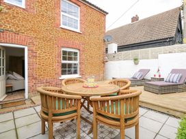 A garden with a table and chairs at Joy's Cottage in Snettisham