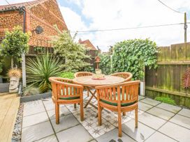 A garden with a table and chairs at Joy's Cottage in Snettisham