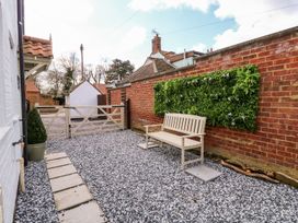 A garden with a gravel area and a bench at Joy's Cottage Snettisham