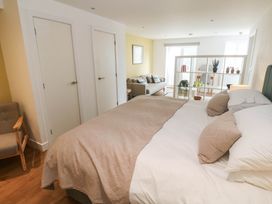 A bedroom with a bed and armchair at 11 Fountain Court in Falmouth
