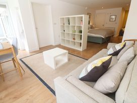 A living room with a sofa, table, and bookshelf at 11 Fountain Court in Falmouth