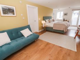 A bedroom with a bed and sofa at 11 Fountain Court in Falmouth