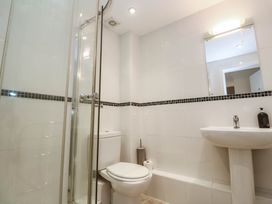 A bathroom with a shower, toilet, and washbasin at 11 Fountain Court in Falmouth