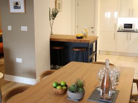 A kitchen with a dining table and bar stools at 11 Fountain Court in Falmouth