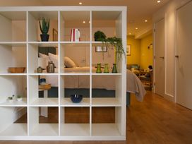 A bedroom with a shelf unit displaying various items at 11 Fountain Court in Falmouth