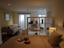 A living room with a sofa and a dining table at 11 Fountain Court in Falmouth