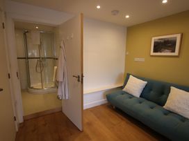 A bathroom with a shower and a couch at 11 Fountain Court in Falmouth