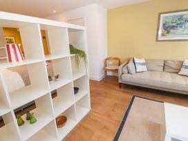 A living room with a shelf and sofa at 11 Fountain Court in Falmouth