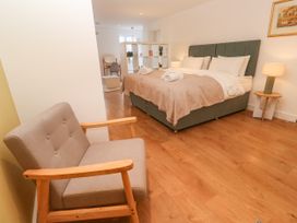 A bedroom with a bed and chair at 11 Fountain Court in Falmouth