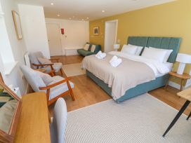 A bedroom with a bed and seating area at 11 Fountain Court in Falmouth