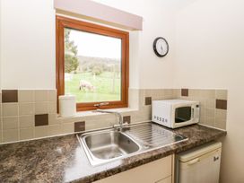 A kitchen with a sink and microwave at Orchard Cottage in Ledbury