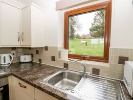 A kitchen with a sink and appliances at Orchard Cottage in Ledbury
