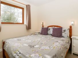 A bedroom with a bed and window at Orchard Cottage in Ledbury