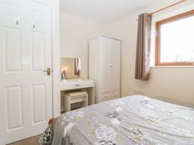 A bedroom with a bed and a wardrobe at Orchard Cottage in Ledbury