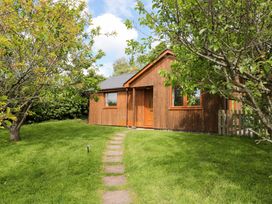 A cottage surrounded by grass and trees at Orchard Cottage in Ledbury