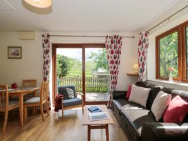 A living room with a sofa and dining table at Orchard Cottage in Ledbury
