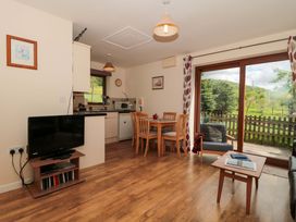 A living room with a television and dining area at Orchard Cottage in Ledbury