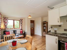A living room with a sofa and dining table at Orchard Cottage in Ledbury