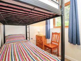 A bedroom with a bunk bed and wooden furniture at Orchard Cottage in Ledbury