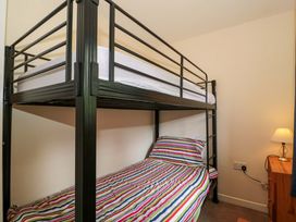 A bedroom with a bunk bed and nightstand at Orchard Cottage in Ledbury